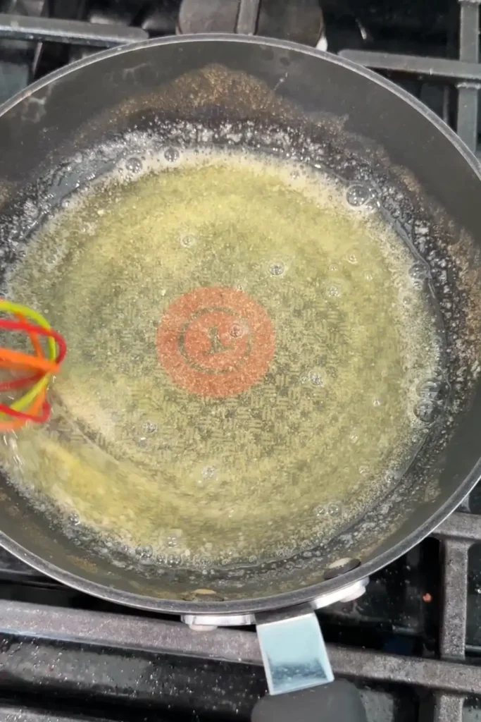 Lemon butter sauce whisked in a pan until smooth and lightly bubbling.