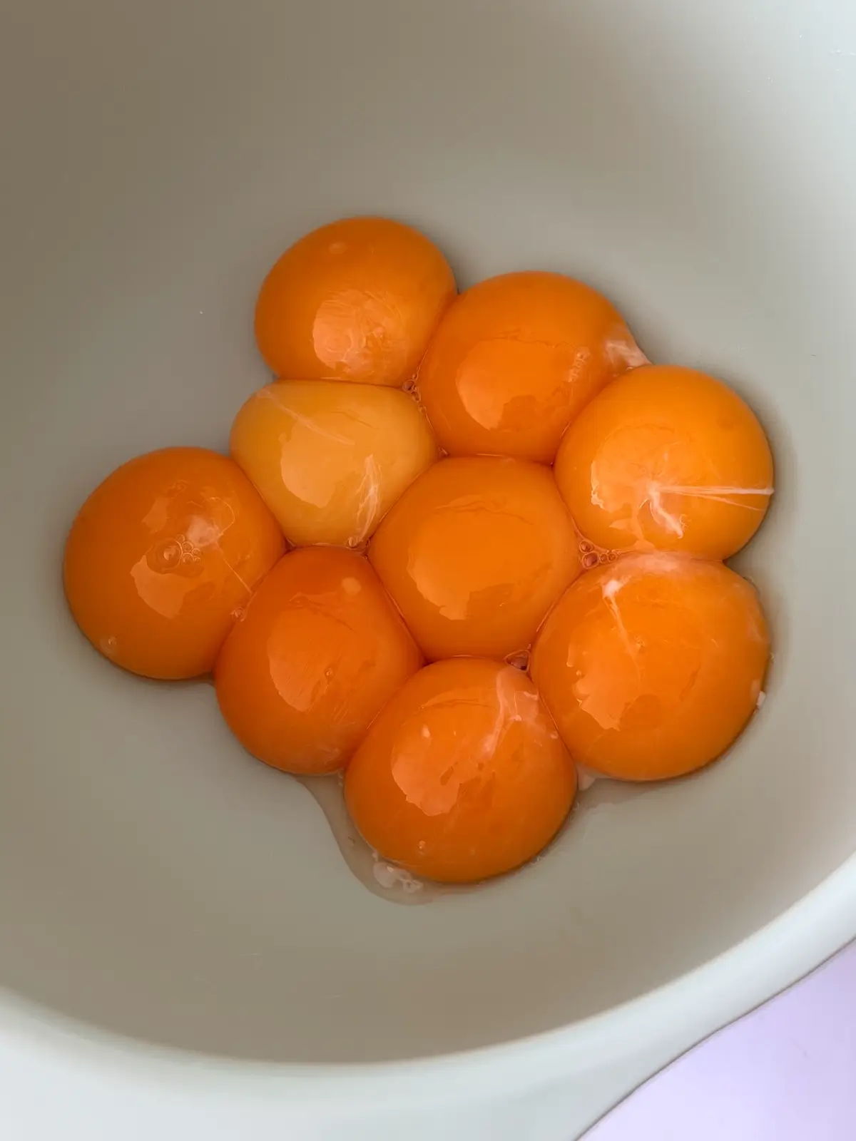 Fresh egg yolks in a mixing bowl.