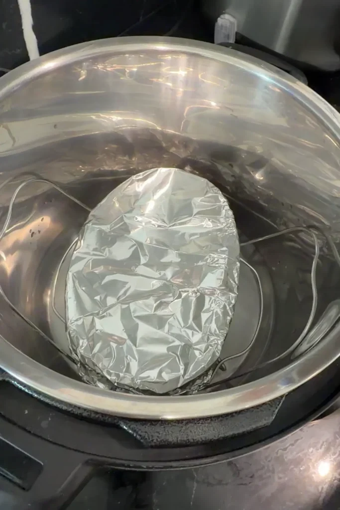 Llanera molds covered with foil and placed on a rack inside an Instant Pot.