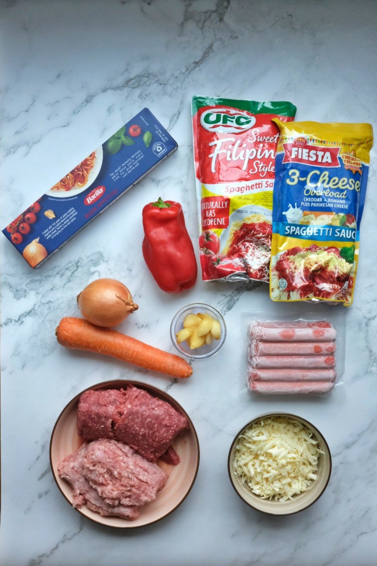 Ingredients for Filipino spaghetti: ground pork and beef, tomato sauce, spaghetti, bell pepper, carrot, garlic, onion, hotdogs