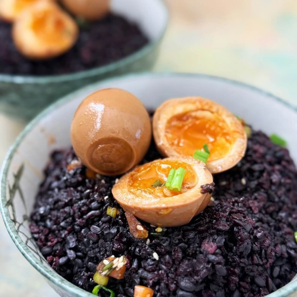 Korean mayak eggs served over rice with chopped scallions