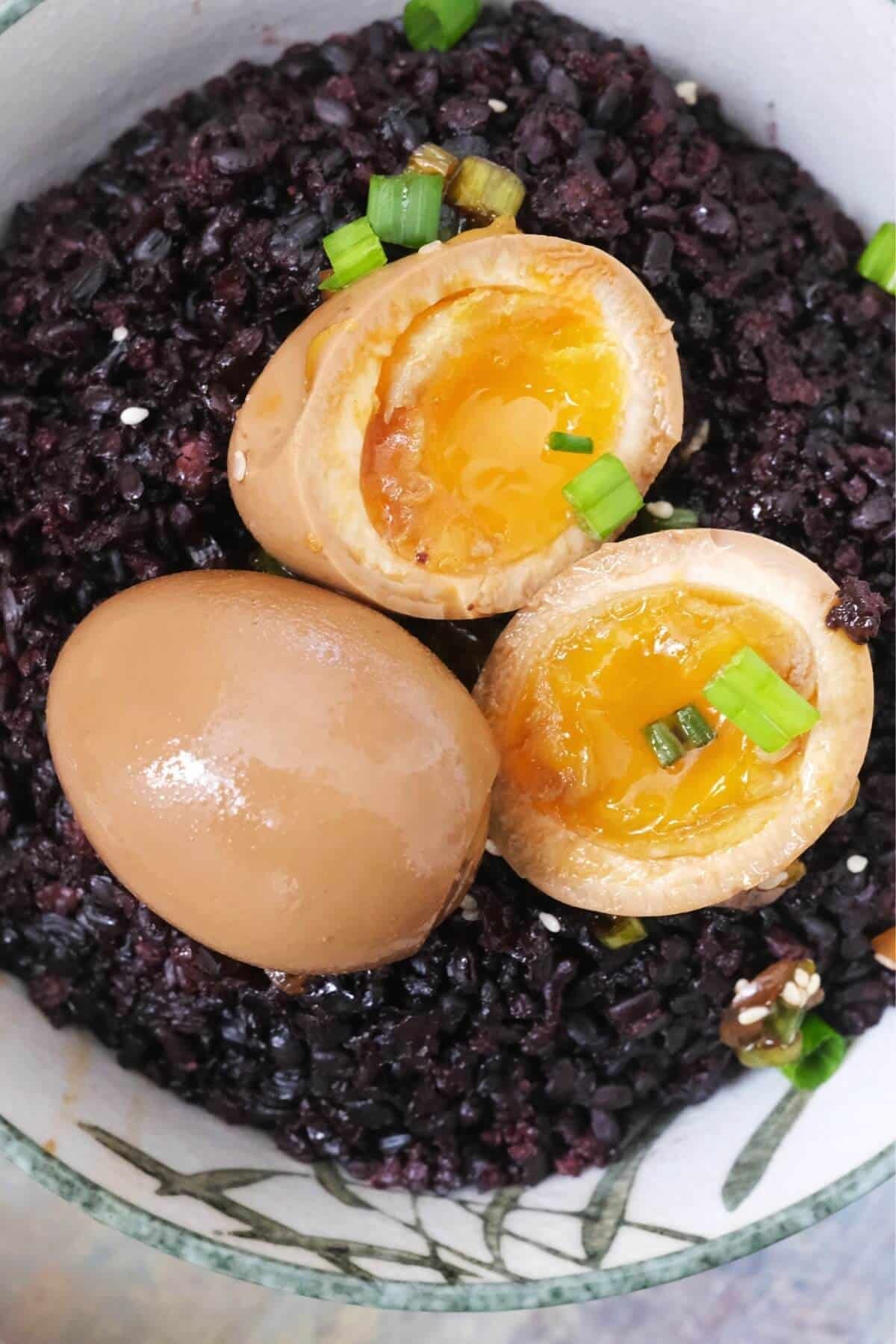 Top-down shot of mayak eggs served over dark purple rice