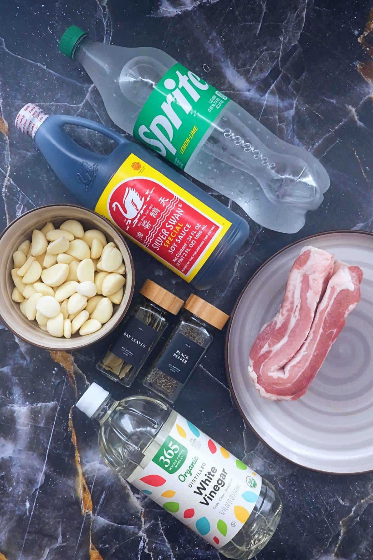 Ingredients for pork adobo: pork belly, garlic, soy sauce, vinegar, Sprite, seasonings