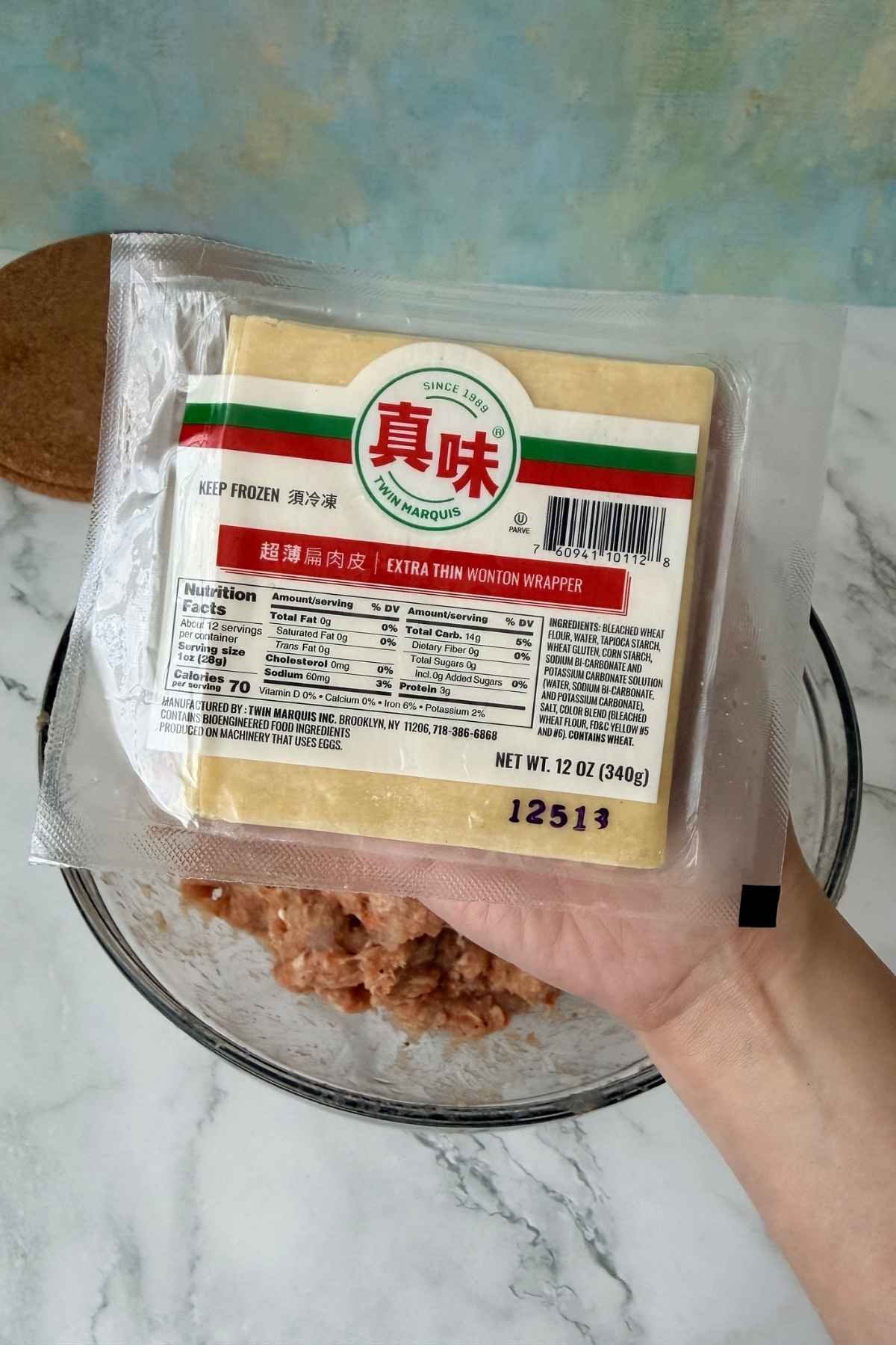 Extra thin wonton wrappers package held above mixing bowl.