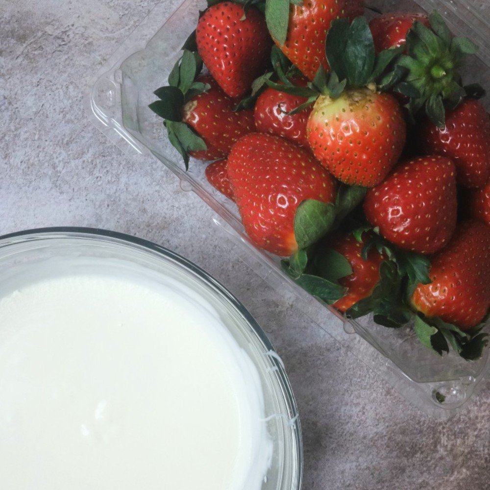 Ingredients for white chocolate covered strawberries: fresh strawberries and melted white chocolate