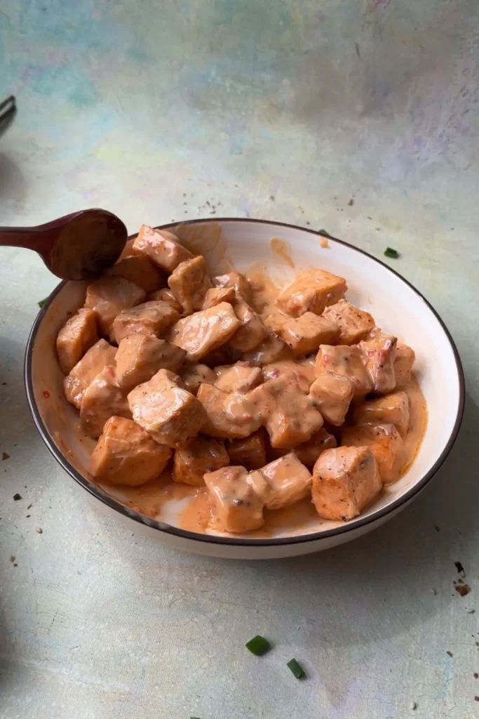 Cooked salmon bites tossed with creamy sweet and spicy bang bang sauce.