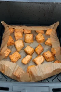 Air fryer salmon bites cooked until tender and lightly golden in the air fryer basket.