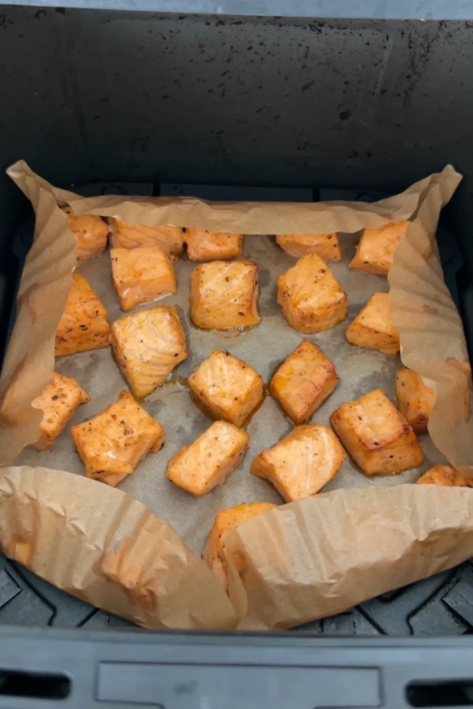 Air fryer salmon bites cooked until tender and lightly golden in the air fryer basket.