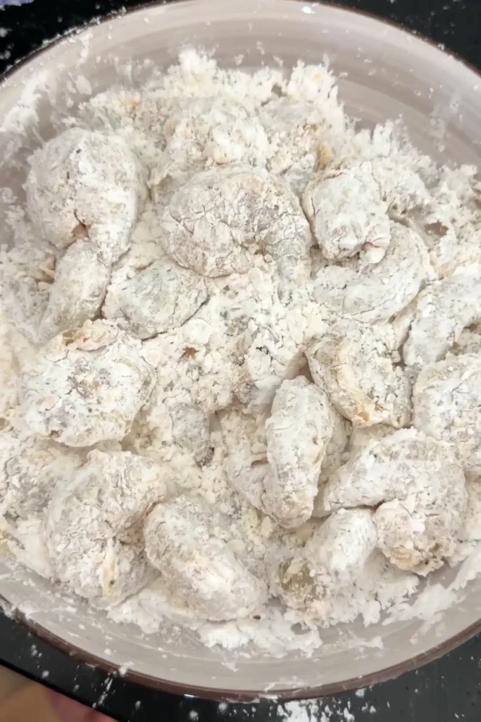 Raw shrimp fully coated in seasoned starch mixture ready for frying