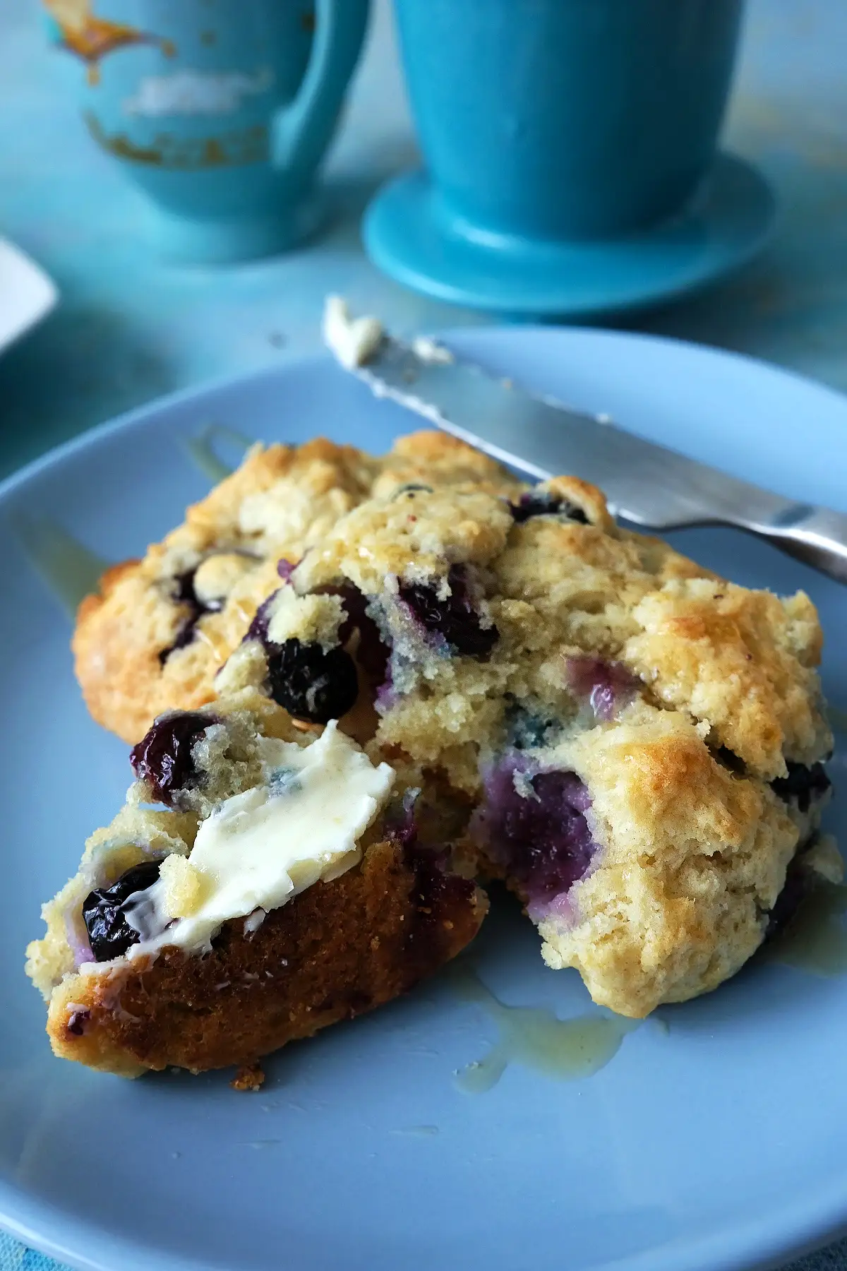 Blueberry biscuit split open with butter.