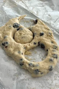 Cutting blueberry biscuit dough with a biscuit cutter.