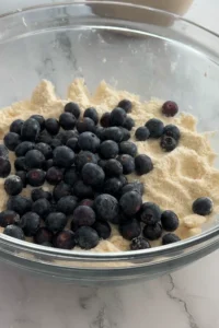 Fresh blueberries added to biscuit dough mixture.