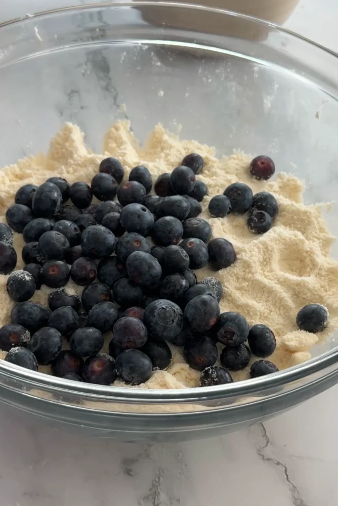 Fresh blueberries added to biscuit dough mixture.