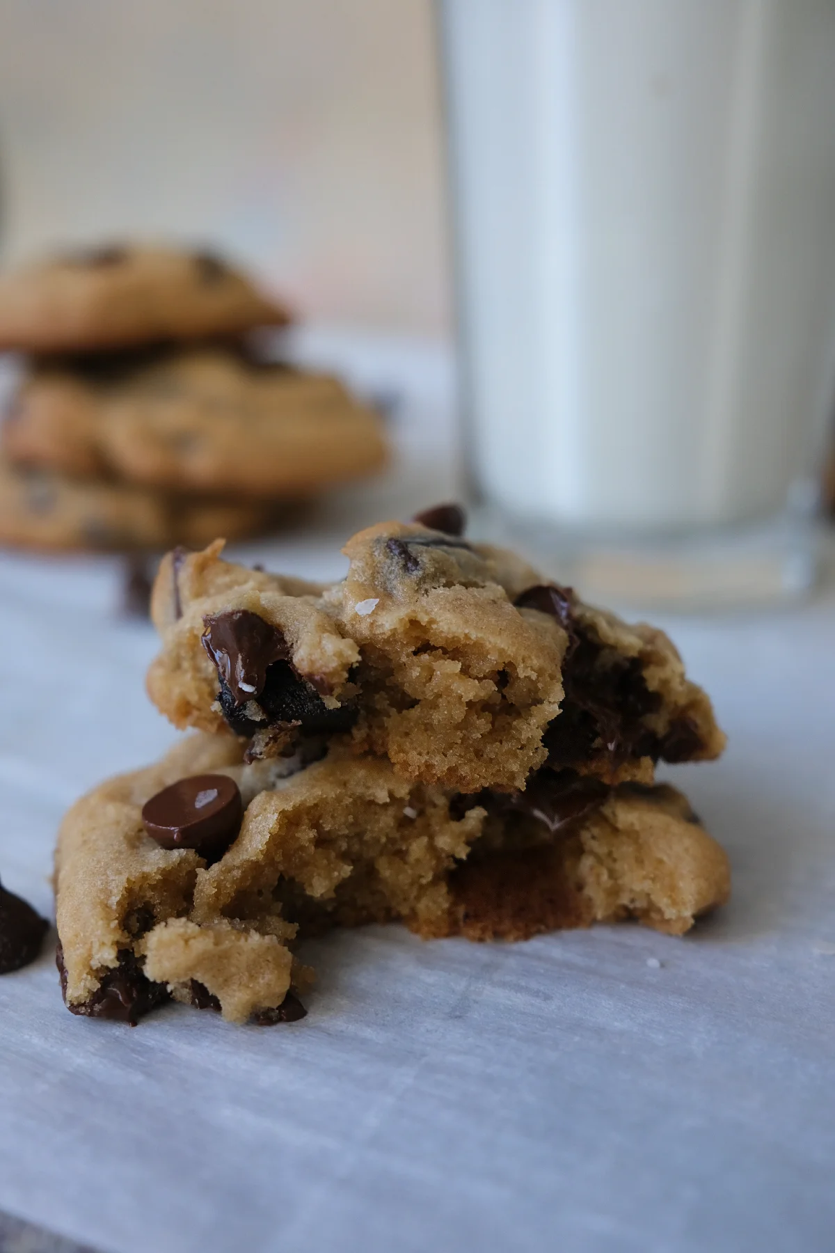 Close-up of a gooey brown sugar chocolate chip cookie broken in half showing melted chocolate inside.