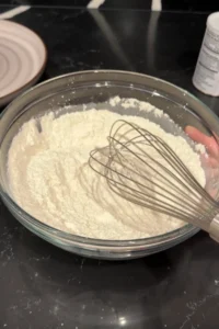 Whisking flour and cornstarch mixture together to prepare fish batter.