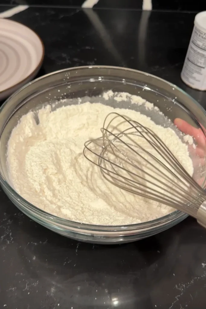 Whisking flour and cornstarch mixture together to prepare fish batter.
