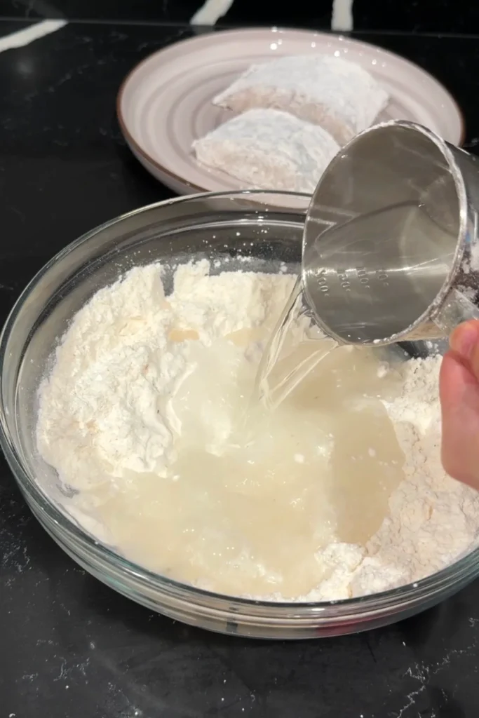 Pouring Sprite into flour mixture to make light and crispy fish batter.