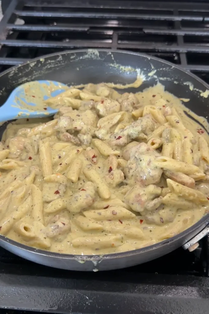 Creamy pesto chicken pasta fully mixed and coated in sauce