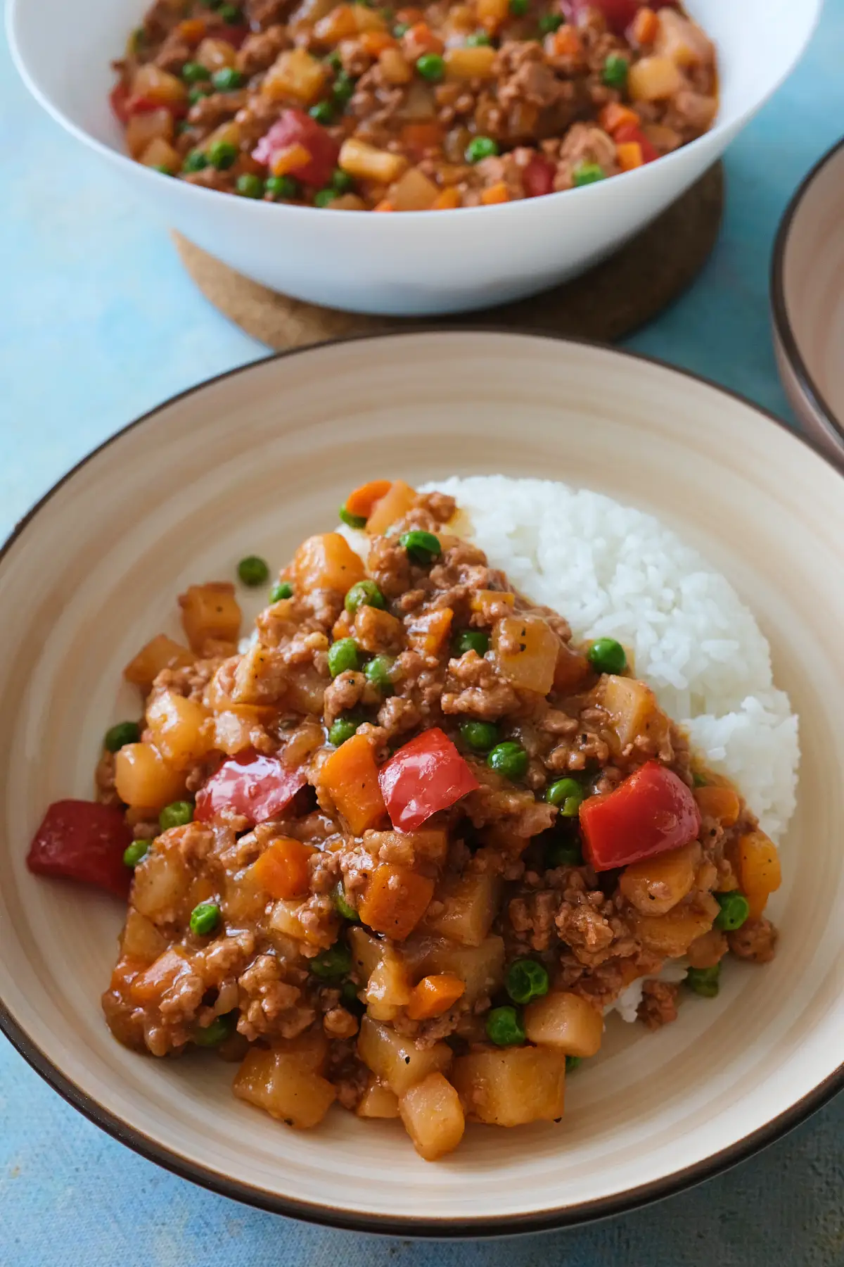Filipino pork picadillo served over white rice with diced vegetables and savory tomato sauce.