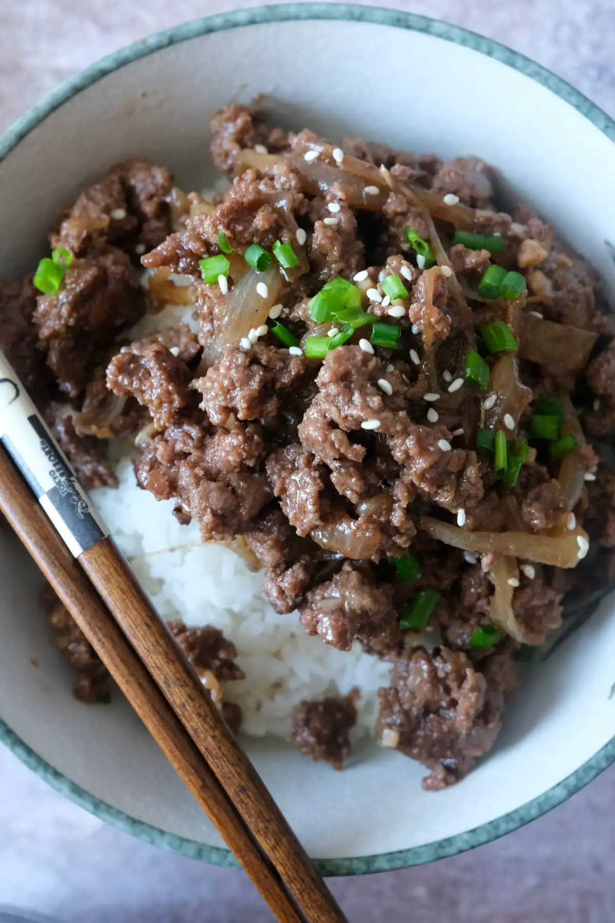 Korean ground beef bulgogi served over white rice in a bowl with chopsticks