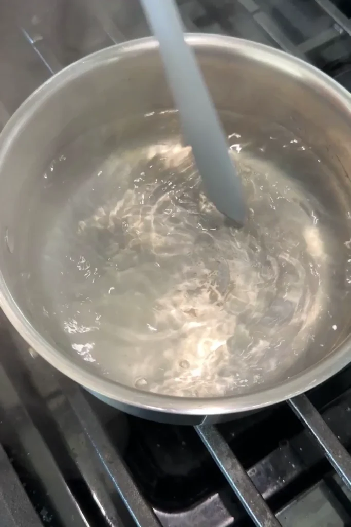 Water swirling in a pot as it heats up for poaching an egg.