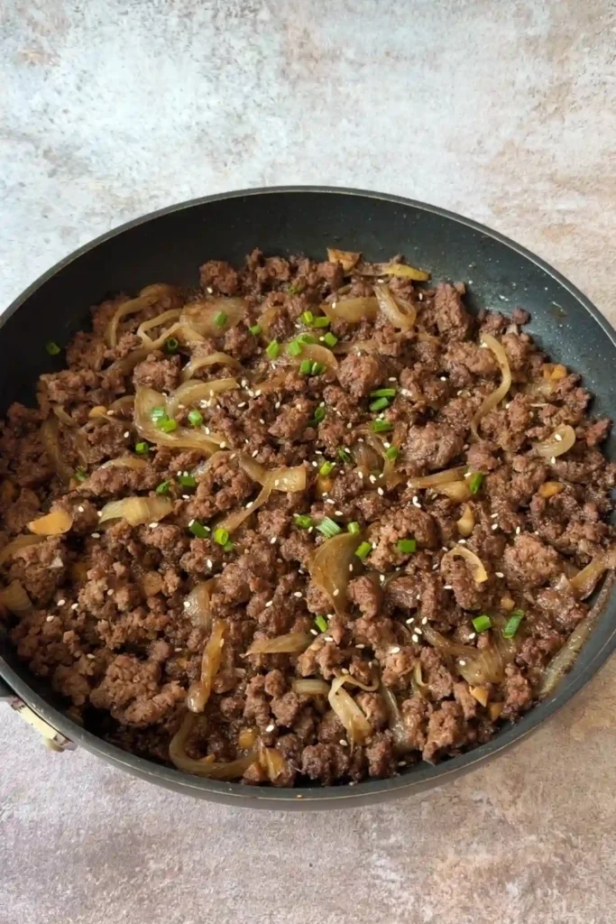 Finished ground beef bulgogi garnished with sesame seeds and chopped green onions.
