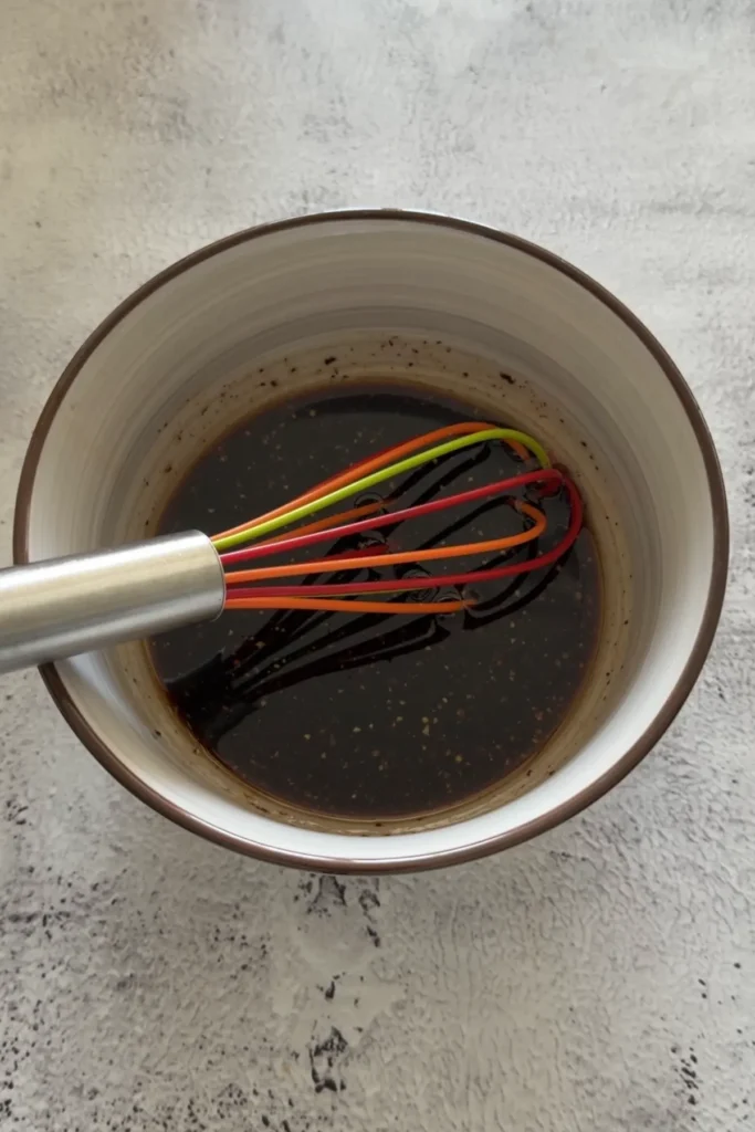 Whisking bulgogi sauce ingredients together in a small bowl
