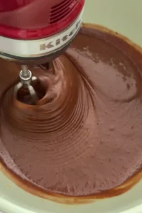 Mixing melted chocolate into whipped egg and sugar mixture for fudgy brownie batter