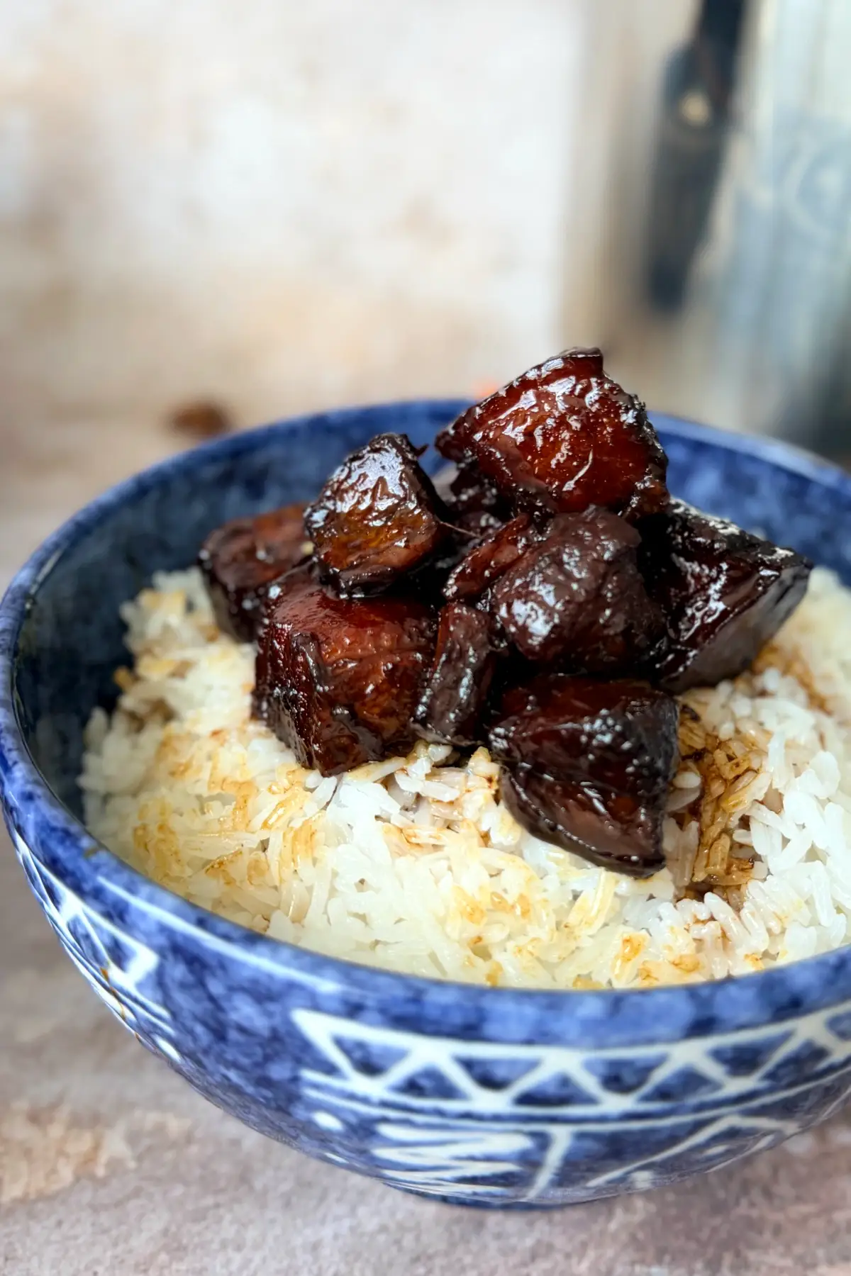 Close-up of sticky Hong Shao Rou pork belly over steamed rice