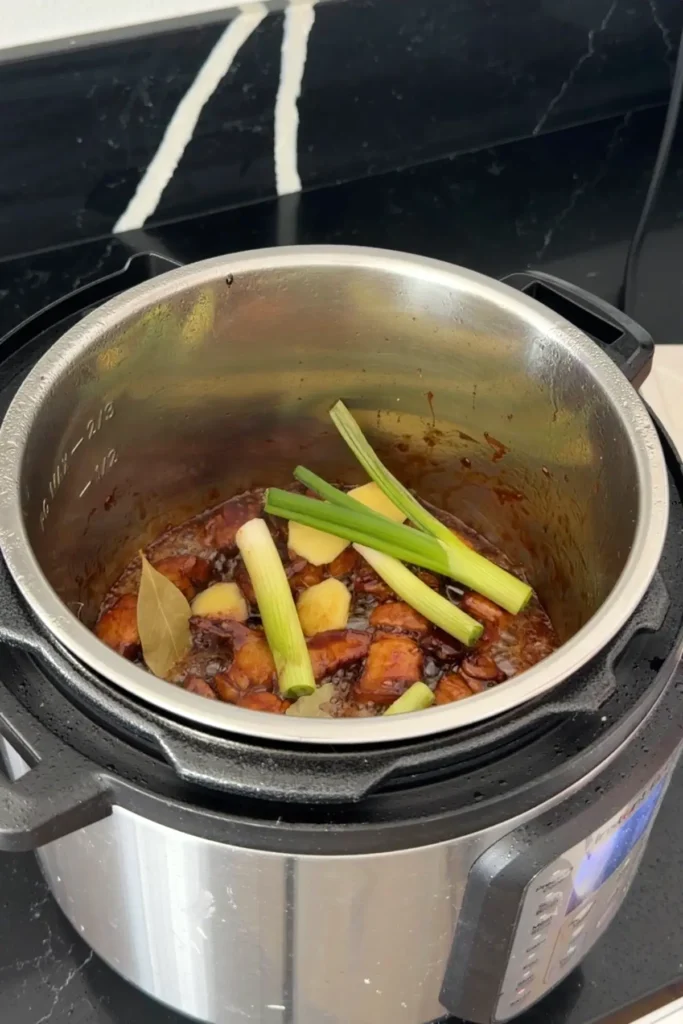 Adding ginger and green onions to braised pork belly in Instant Pot