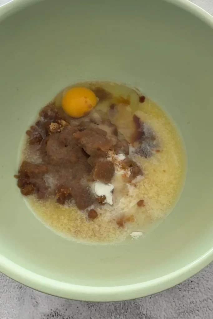 Ingredients for matcha white chocolate cookies arranged on a counter, including flour, butter, egg, vanilla, sugar, matcha powder, and white chocolate.