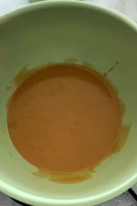 Overhead view of matcha white chocolate cookies on a cooling rack with white chocolate chips and flaky salt.