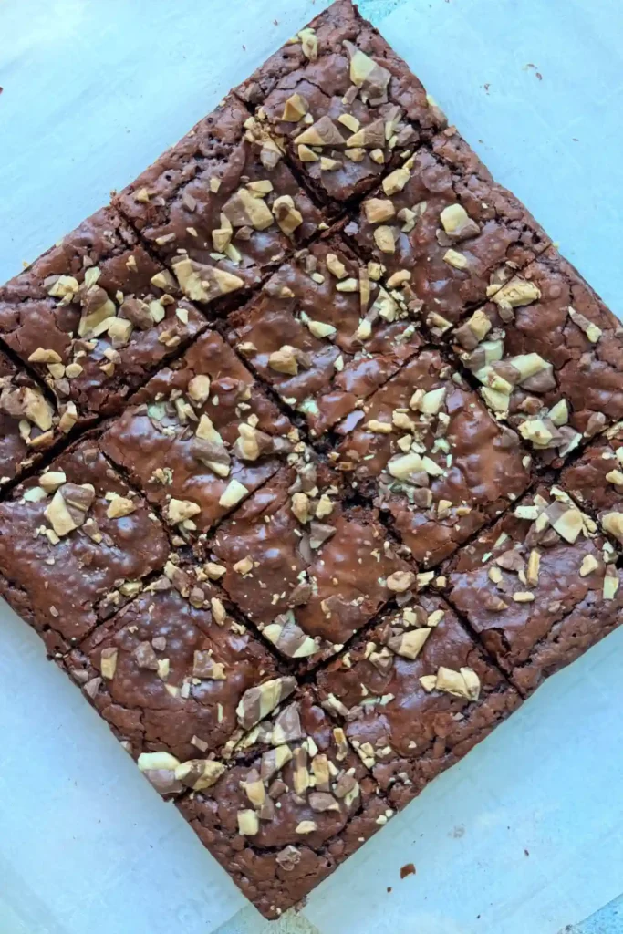 Brownies cut into squares in pan showing crackly tops and soft centers