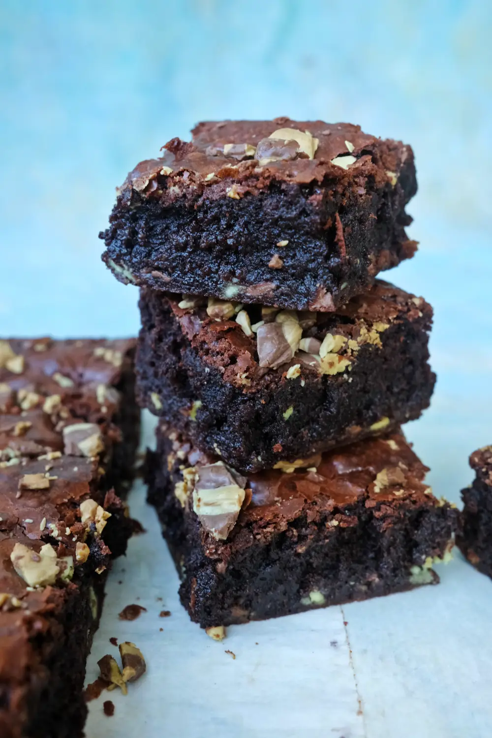 Mint chocolate chip brownies stacked showing fudgy centers and crackly tops