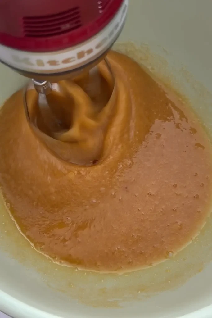 Beating eggs and sugar with hand mixer until thick and foamy