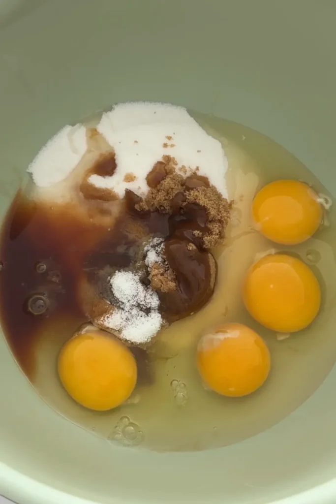 Eggs, sugar, brown sugar, vanilla, and salt in bowl before mixing brownie batter