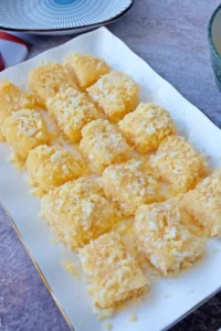 Soft and chewy pichi pichi pieces topped with grated cheese on a white plate
