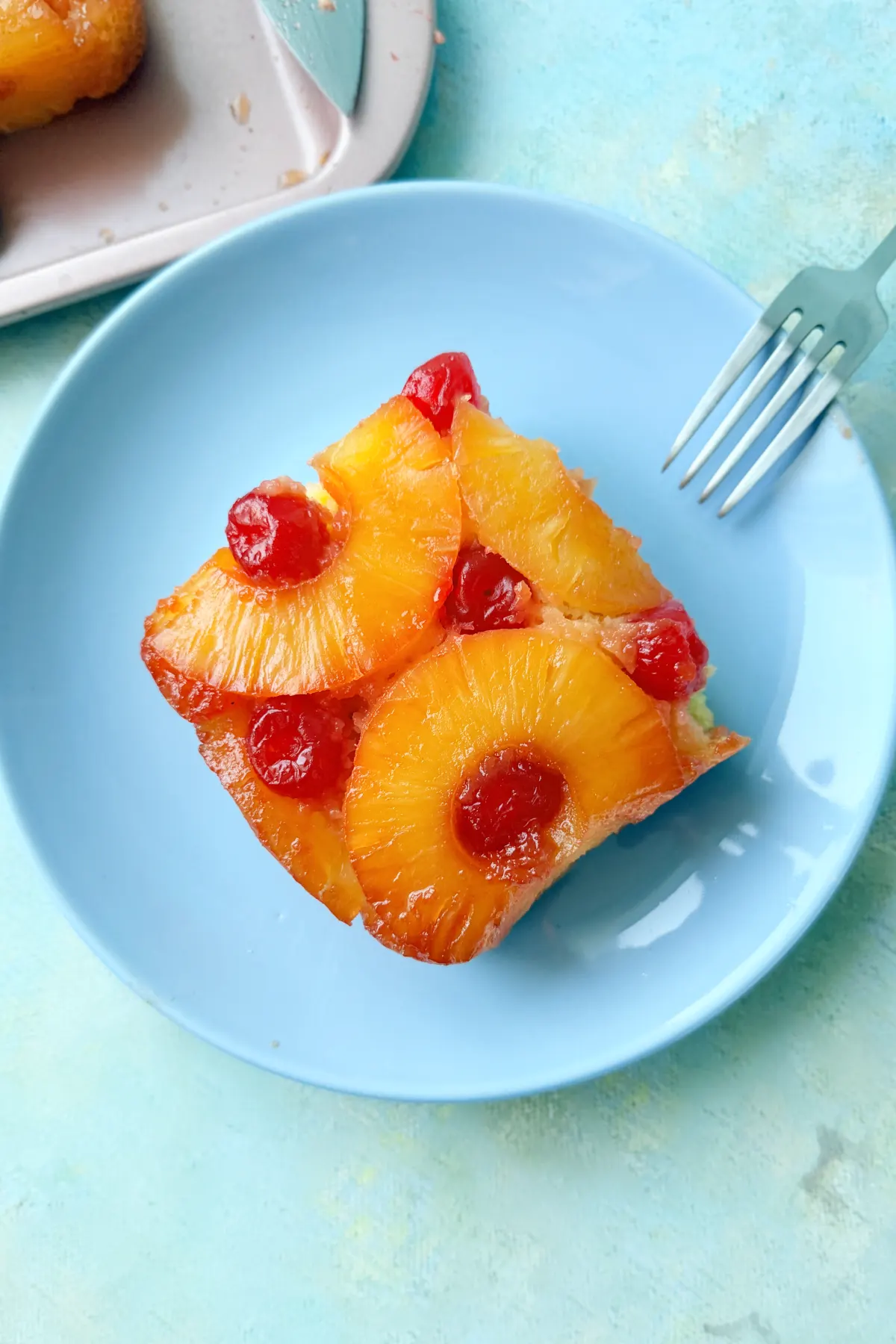 Pineapple upside down cake slice served on a blue plate