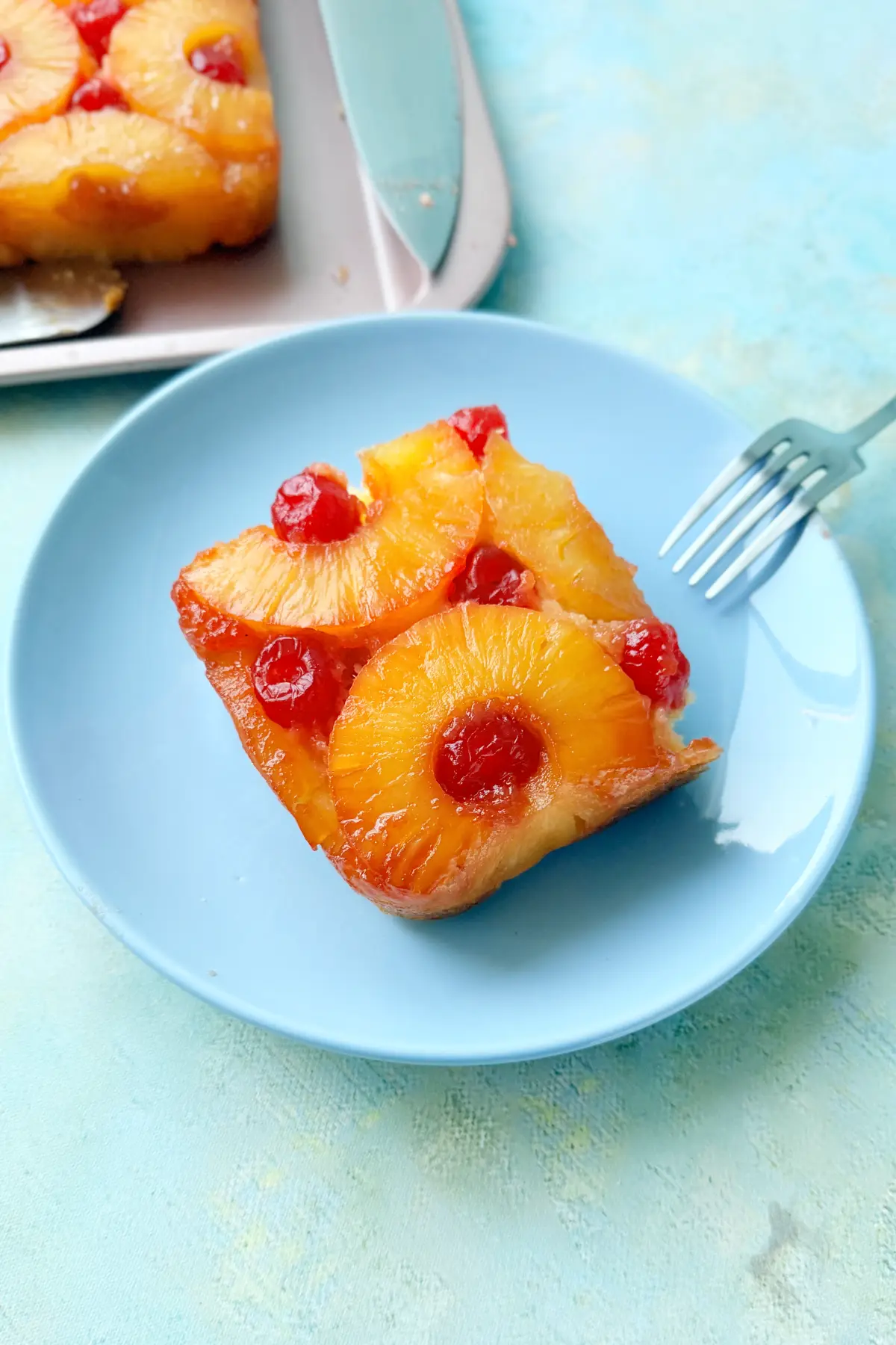 Close-up of pineapple upside down cake slice topped with pineapple rings and cherries