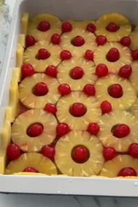 Maraschino cherries placed in the center of pineapple slices before baking