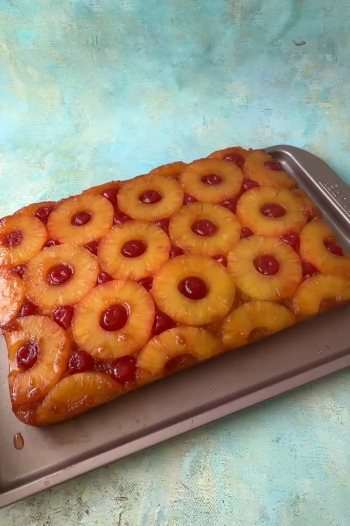 Pineapple upside down cake flipped onto a tray showing caramelized pineapple rings and cherries on top