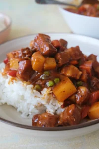 pork menudo spooned over steamed white rice