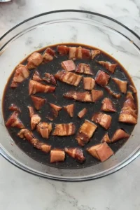 pork belly marinating in soy sauce and lemon juice for pork menudo