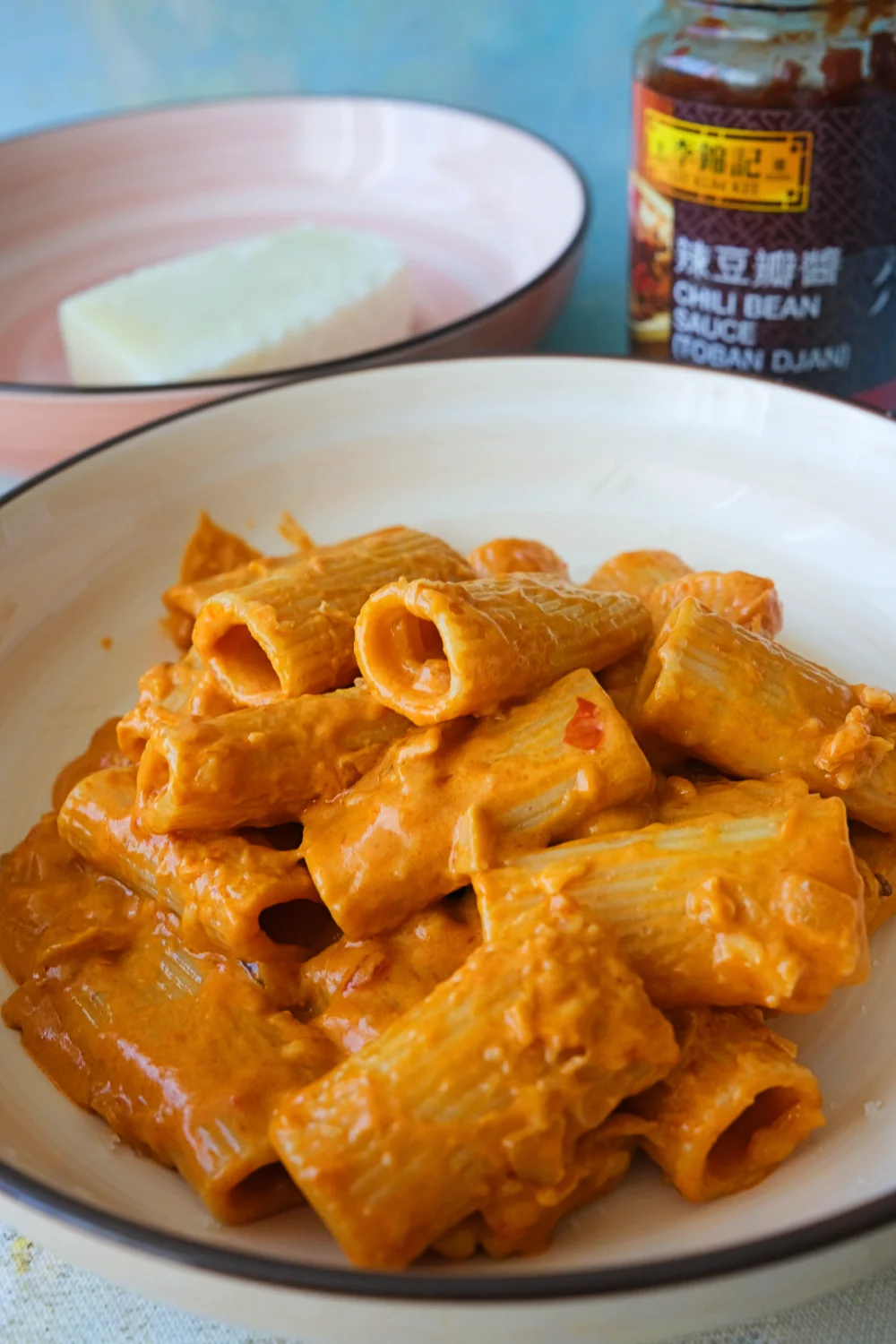 Extreme close-up of rigatoni coated in creamy spicy sauce, showing the hollow centers of the pasta.
