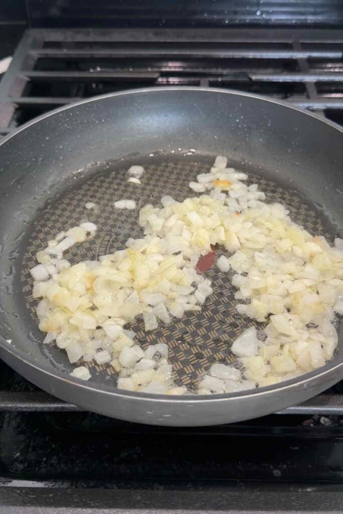 Softened onion and garlic cooking in olive oil in a skillet.