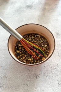 Honey garlic sauce mixture with soy sauce and chopped garlic being whisked