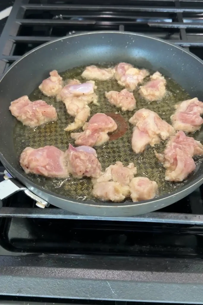 Chicken pieces frying in hot oil in a skillet