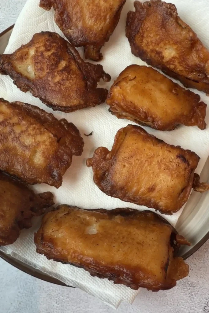 Golden brown fried cod pieces cooking in a pan