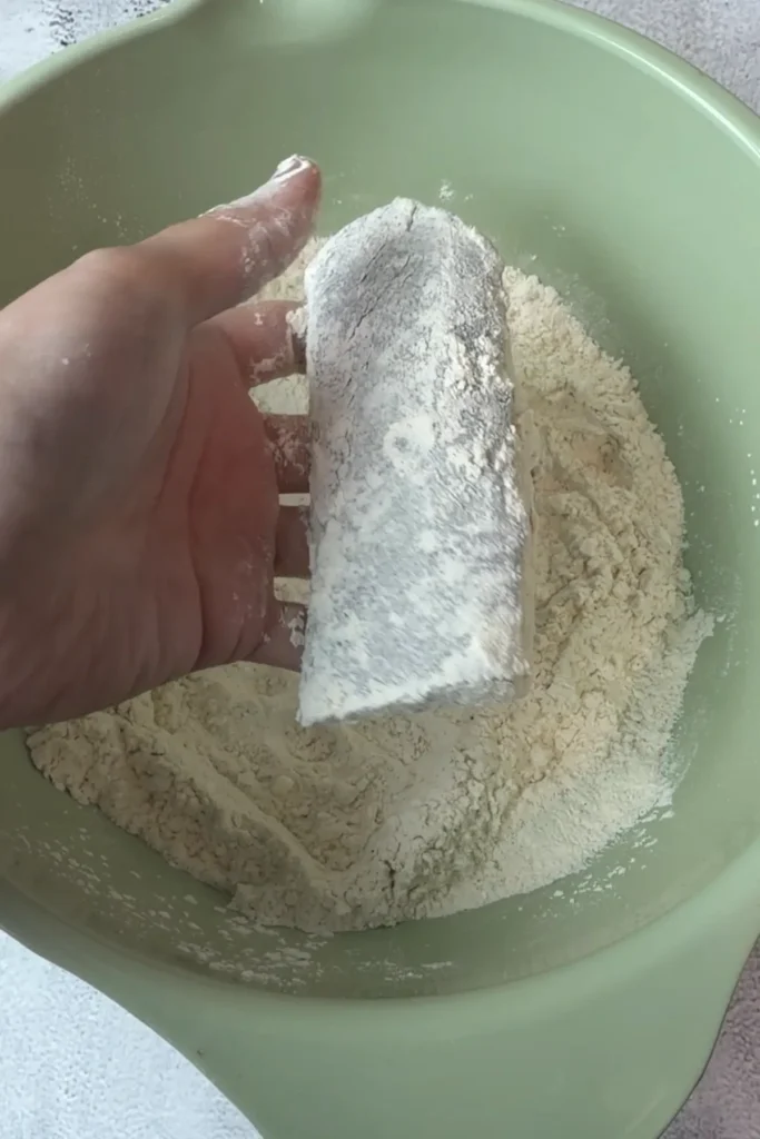 Piece of cod fish dredged in seasoned flour mixture