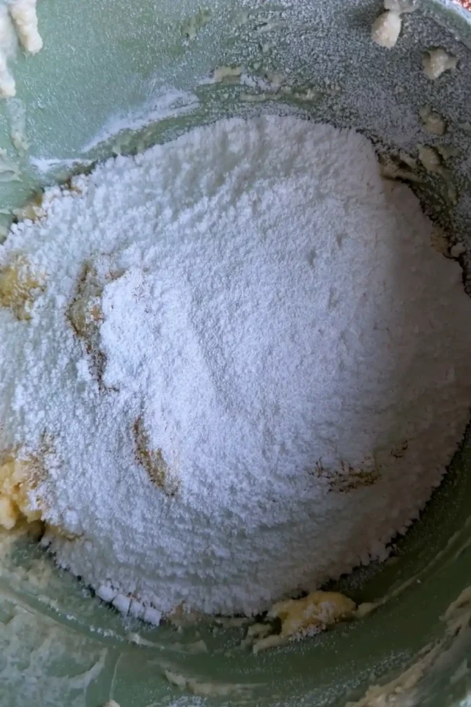 Powdered sugar added on top of the whipped butter and cream cheese mixture before mixing into the frosting.